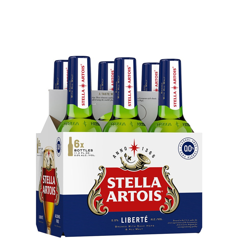 A 6-pack cardboard carrier of Stella Artois Liberté 2% alcohol-free beer, showing six green glass bottles with blue caps inside a white, blue, and red branded carton.