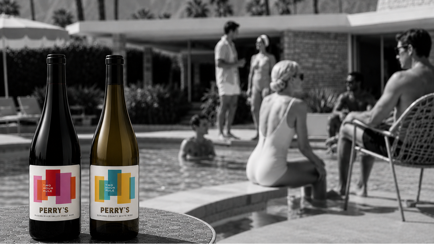 Two bottles of Perry's wine on a table with a poolside scene and people in the background.